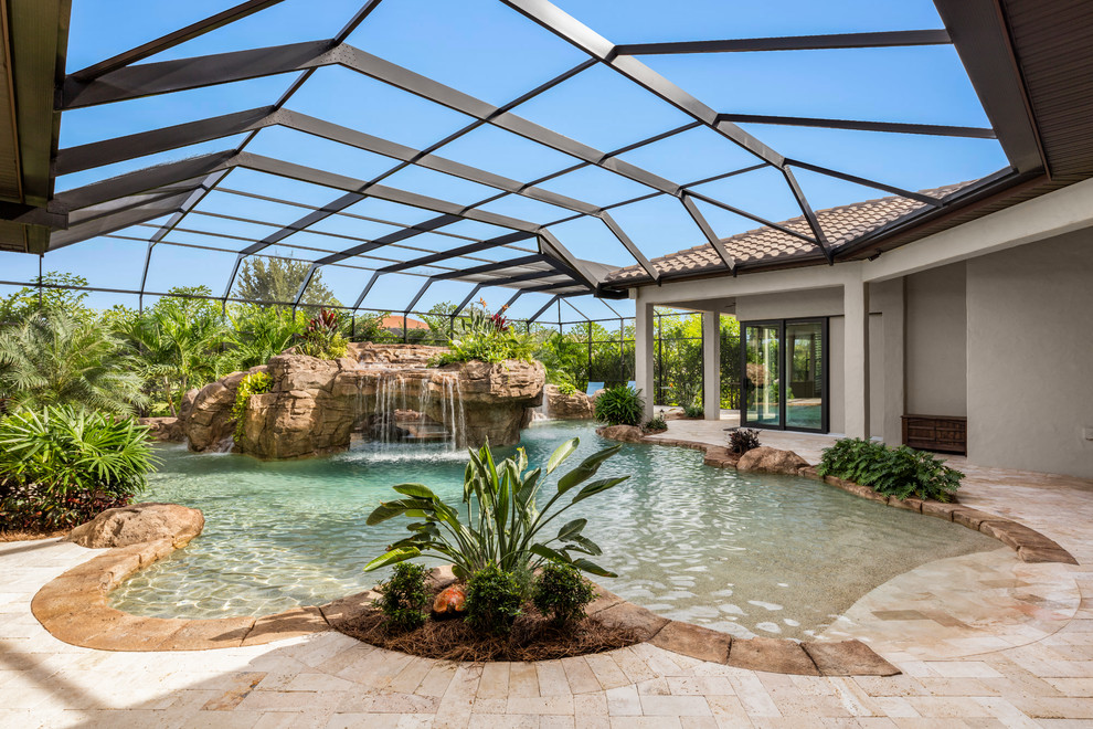 Imagen de piscina con fuente natural mediterránea grande a medida en patio trasero con adoquines de piedra natural