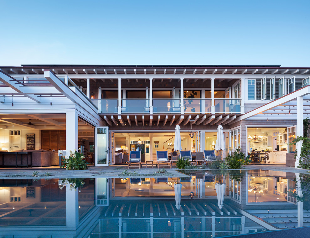 Großer Maritimer Pool hinter dem Haus mit Wasserspiel und Betonplatten in San Diego
