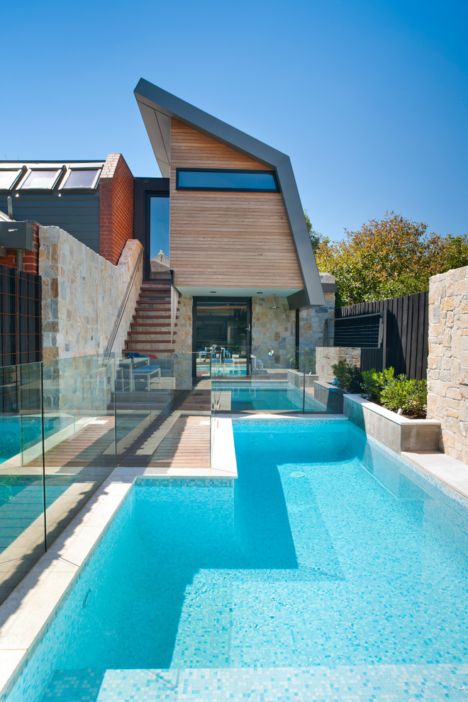 Imagen de piscina actual rectangular en patio trasero