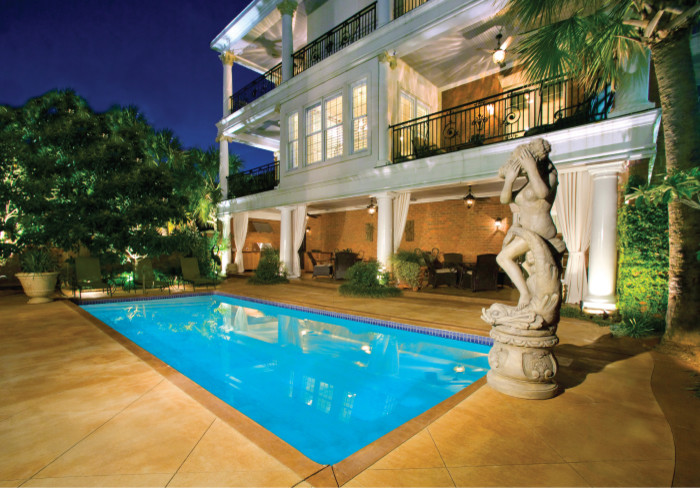 Foto di una piscina monocorsia mediterranea rettangolare di medie dimensioni e dietro casa con lastre di cemento