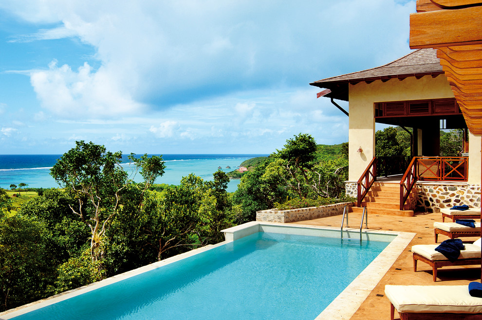 Imagen de piscina infinita tropical rectangular en patio lateral