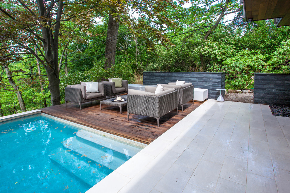Cette photo montre une piscine moderne rectangle avec une terrasse en bois.
