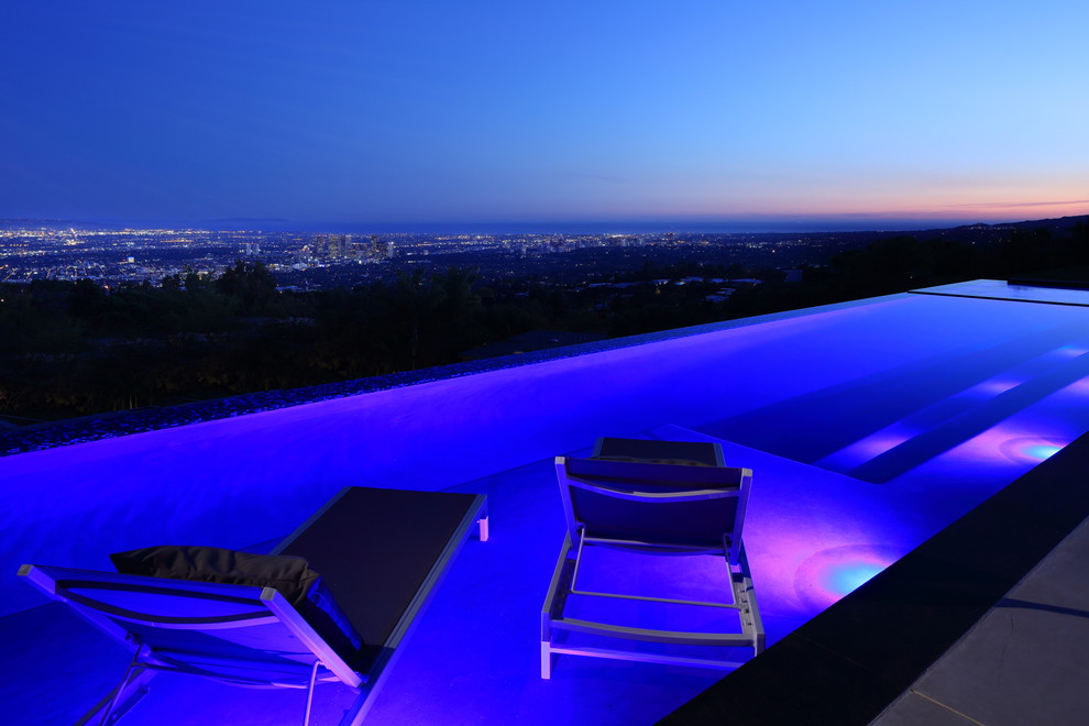 Inspiration for a large modern back rectangular natural swimming pool in Los Angeles with concrete slabs.
