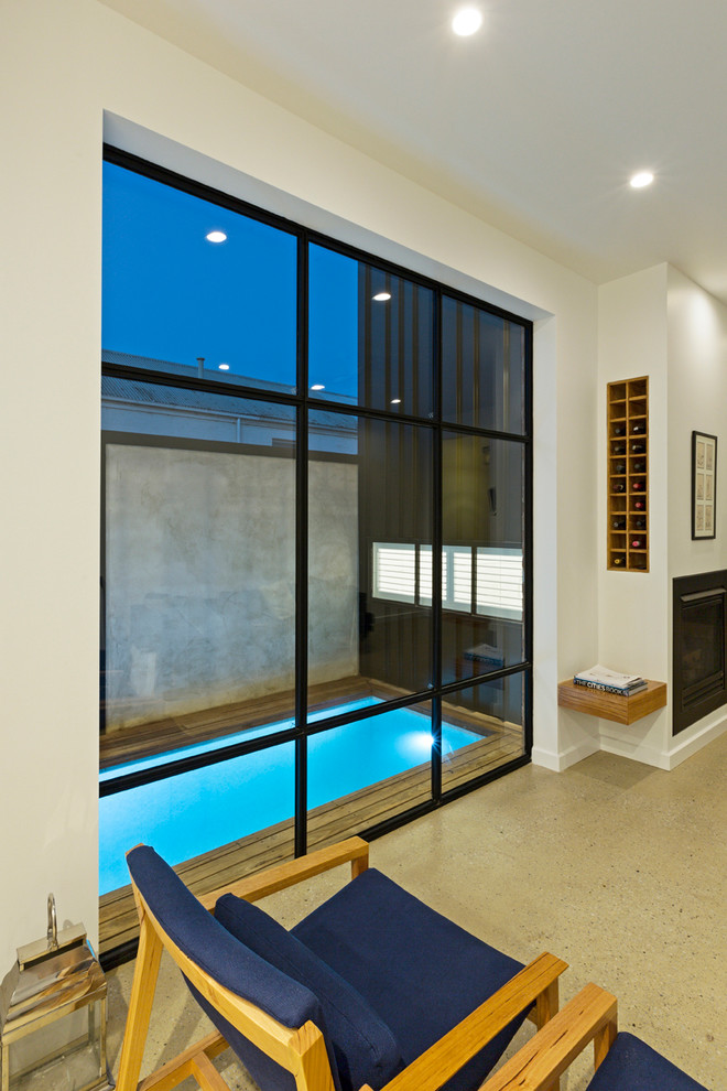 Imagen de piscina contemporánea pequeña rectangular en patio lateral con entablado