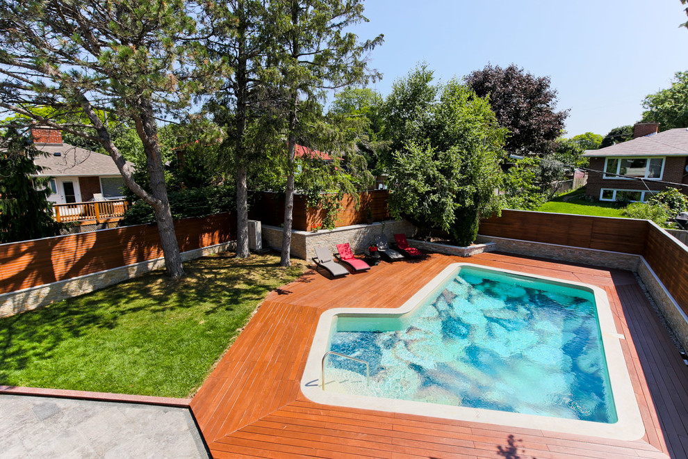 Foto de piscina contemporánea de tamaño medio a medida en patio trasero con entablado