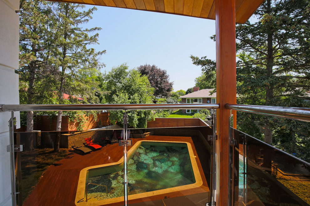 Foto di una piscina design personalizzata di medie dimensioni e dietro casa con pedane
