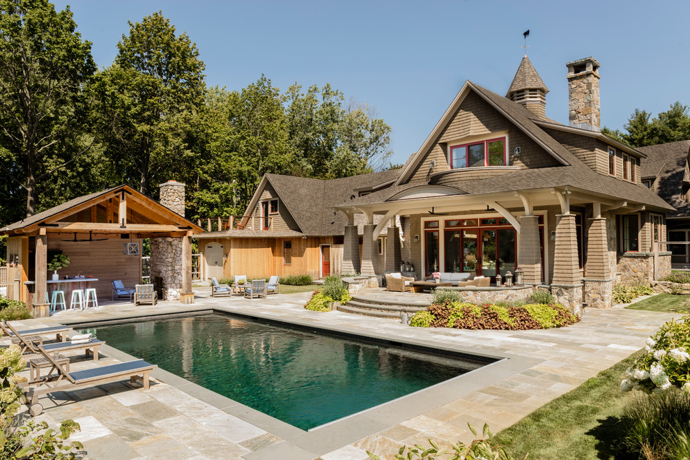 Imagen de piscina alargada tradicional rectangular en patio trasero con suelo de baldosas