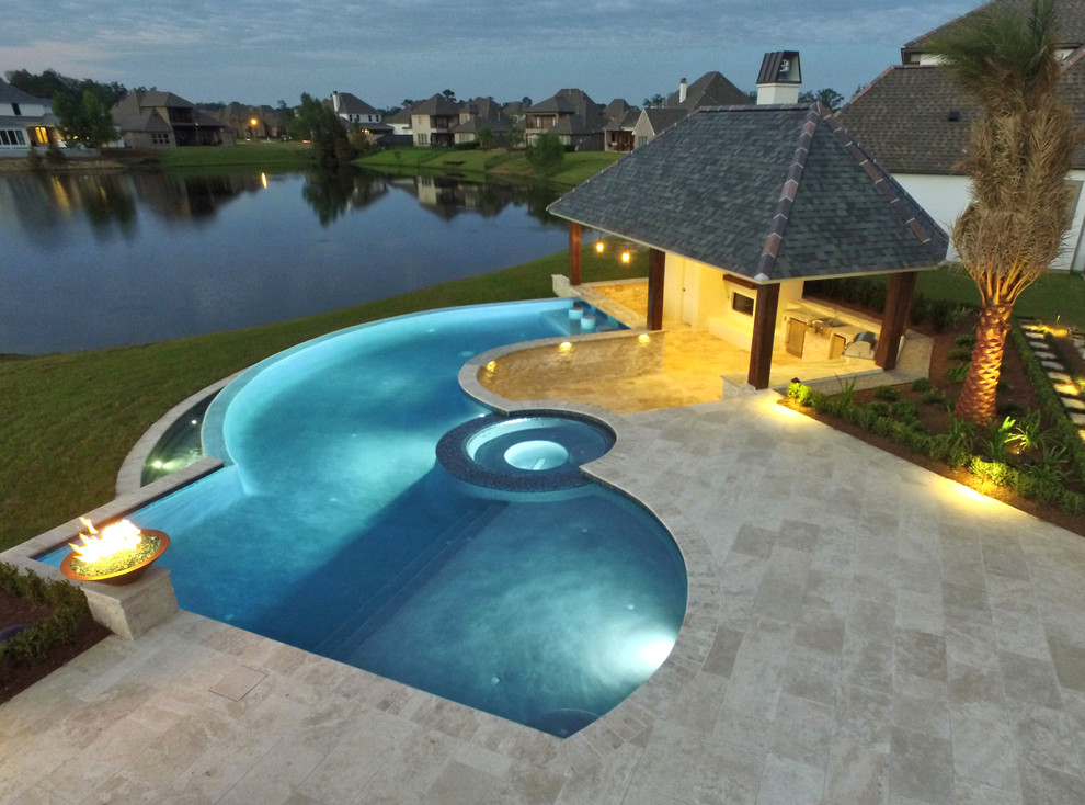 Immagine di una grande piscina a sfioro infinito contemporanea personalizzata dietro casa con una dépendance a bordo piscina e pedane