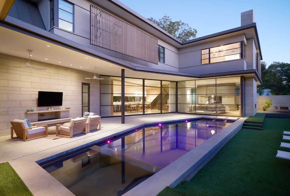 Foto di una piscina monocorsia design rettangolare di medie dimensioni e dietro casa con una vasca idromassaggio e pavimentazioni in pietra naturale