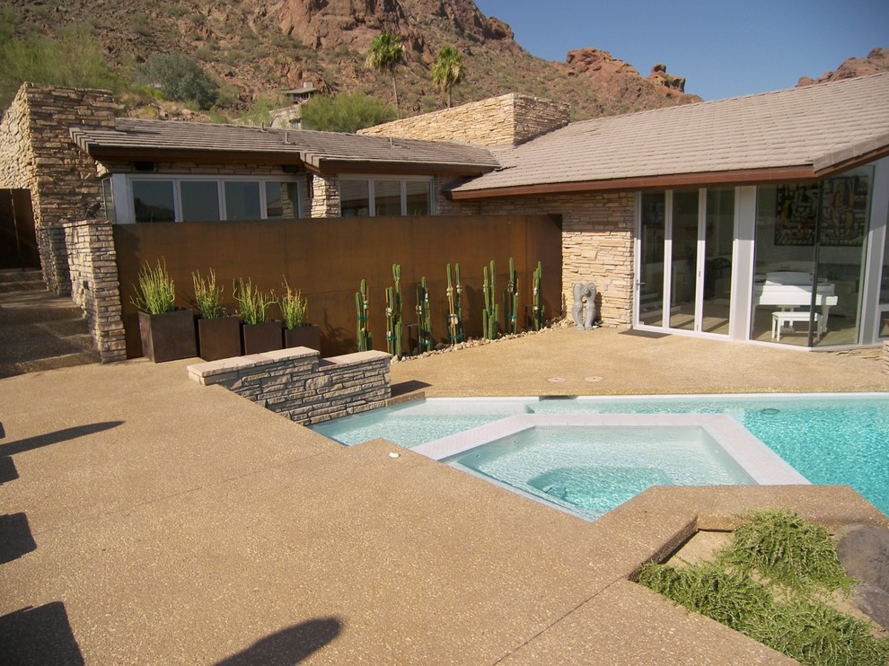 Ejemplo de piscinas y jacuzzis infinitos de estilo americano de tamaño medio a medida en patio lateral con losas de hormigón