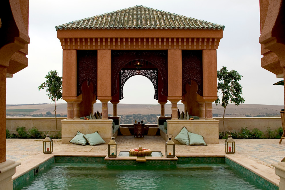 Foto di una grande piscina mediterranea dietro casa con fontane e pavimentazioni in pietra naturale