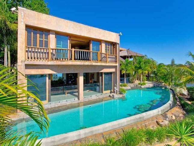 Geräumiger Schwimmteich hinter dem Haus in individueller Form mit Wasserspiel und Natursteinplatten in Sydney