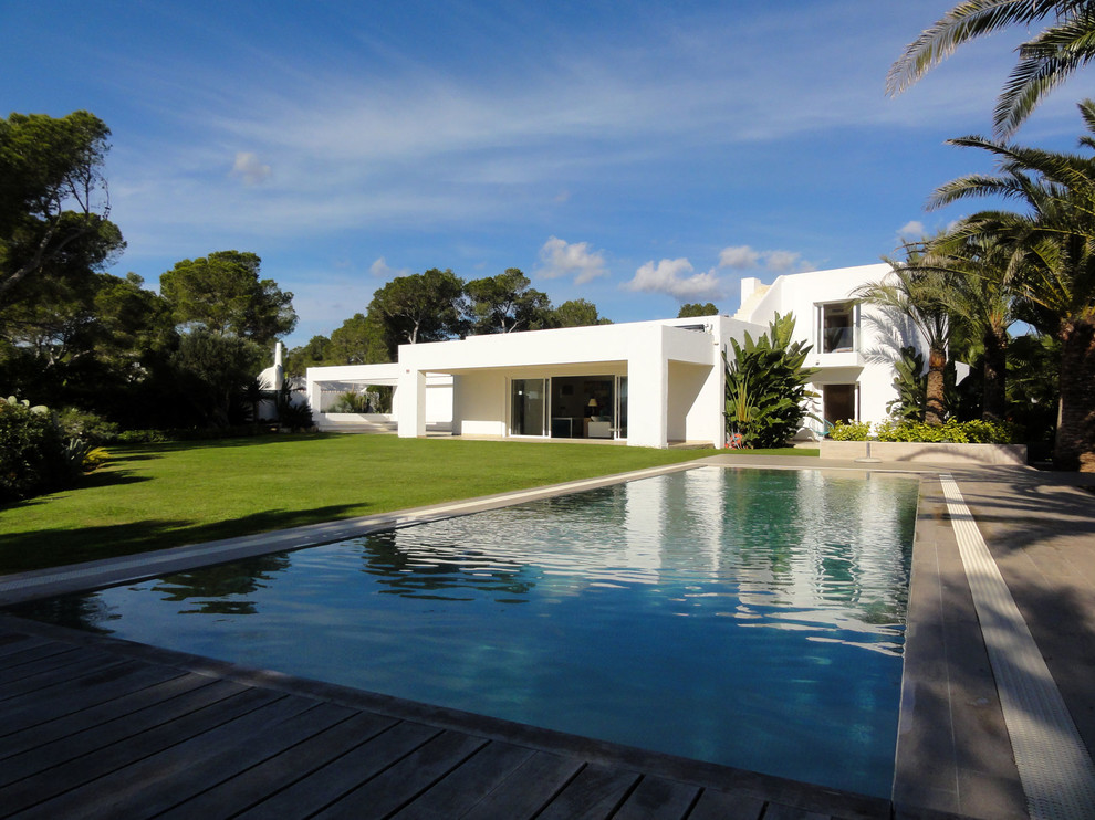 Foto de piscina alargada mediterránea grande rectangular en patio trasero con entablado