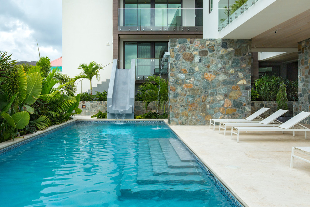 Foto di una grande piscina moderna rettangolare dietro casa con un acquascivolo