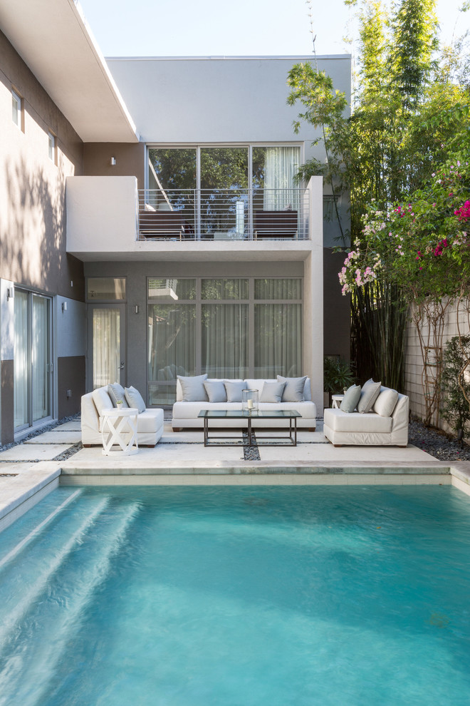 Idee per una piscina minimal rettangolare di medie dimensioni e dietro casa con pavimentazioni in cemento