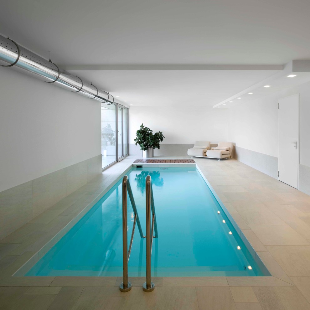 На фото: прямоугольный бассейн в доме в современном стиле с покрытием из плитки