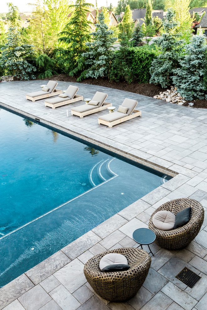 Idee per una grande piscina monocorsia tradizionale rettangolare dietro casa con pavimentazioni in pietra naturale