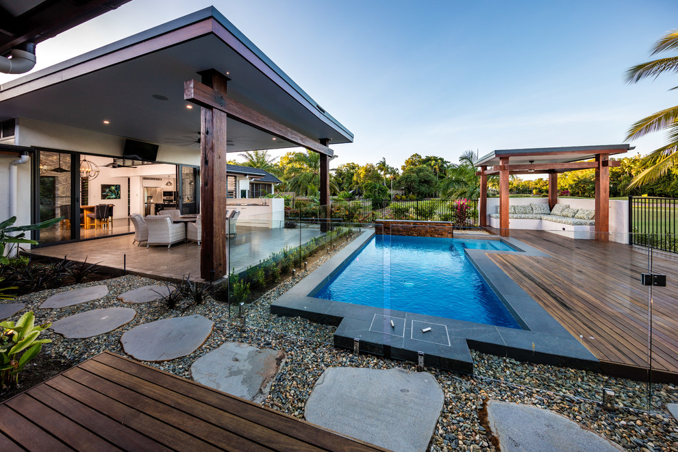 Island style backyard rectangular lap pool photo in Cairns with decking