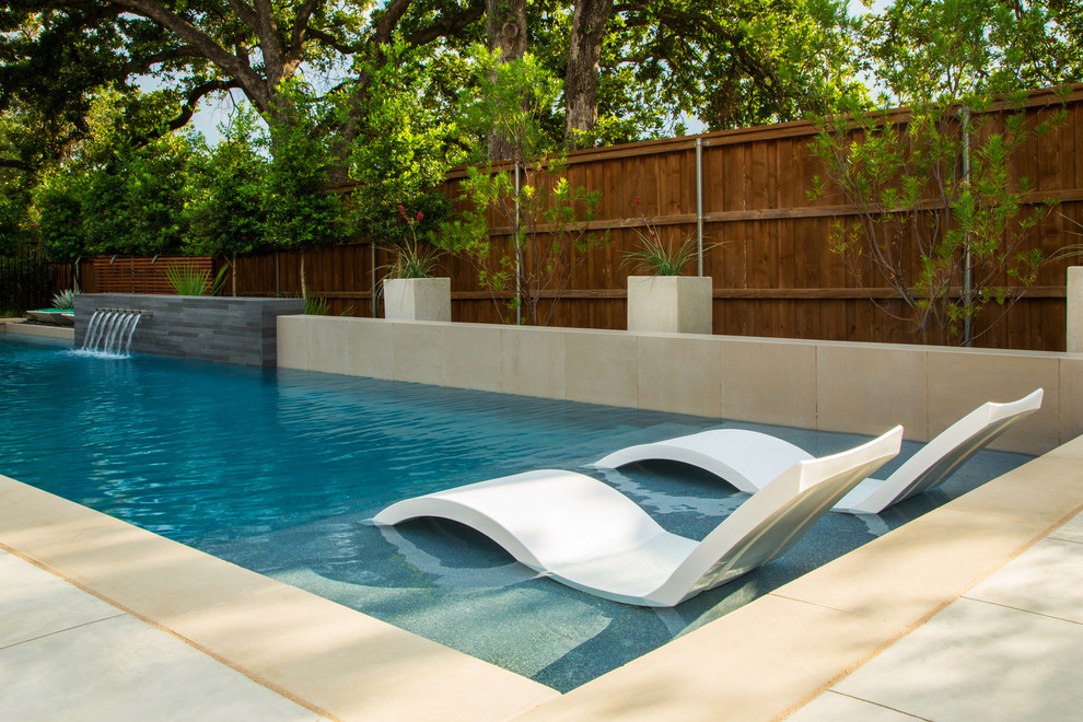 Inspiration for a contemporary back rectangular lengths swimming pool in Dallas with a water feature and concrete slabs.