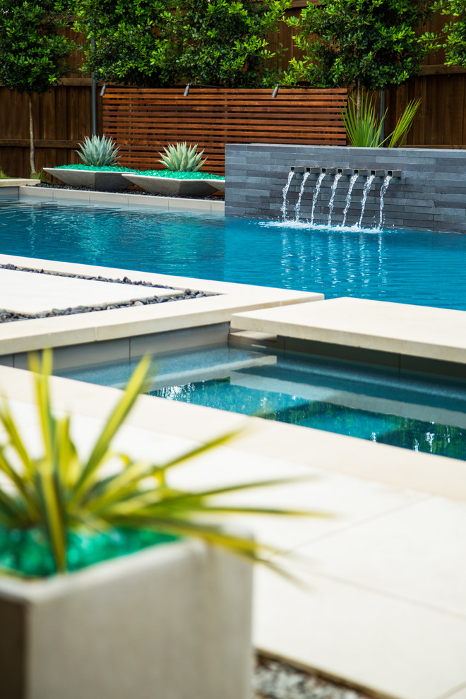 Пример оригинального дизайна: спортивный, прямоугольный бассейн на заднем дворе в современном стиле с фонтаном и покрытием из бетонных плит
