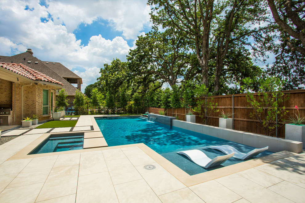Imagen de piscina con fuente alargada contemporánea rectangular en patio trasero con losas de hormigón