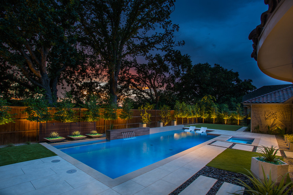 Modelo de piscina con fuente alargada contemporánea rectangular en patio trasero con losas de hormigón