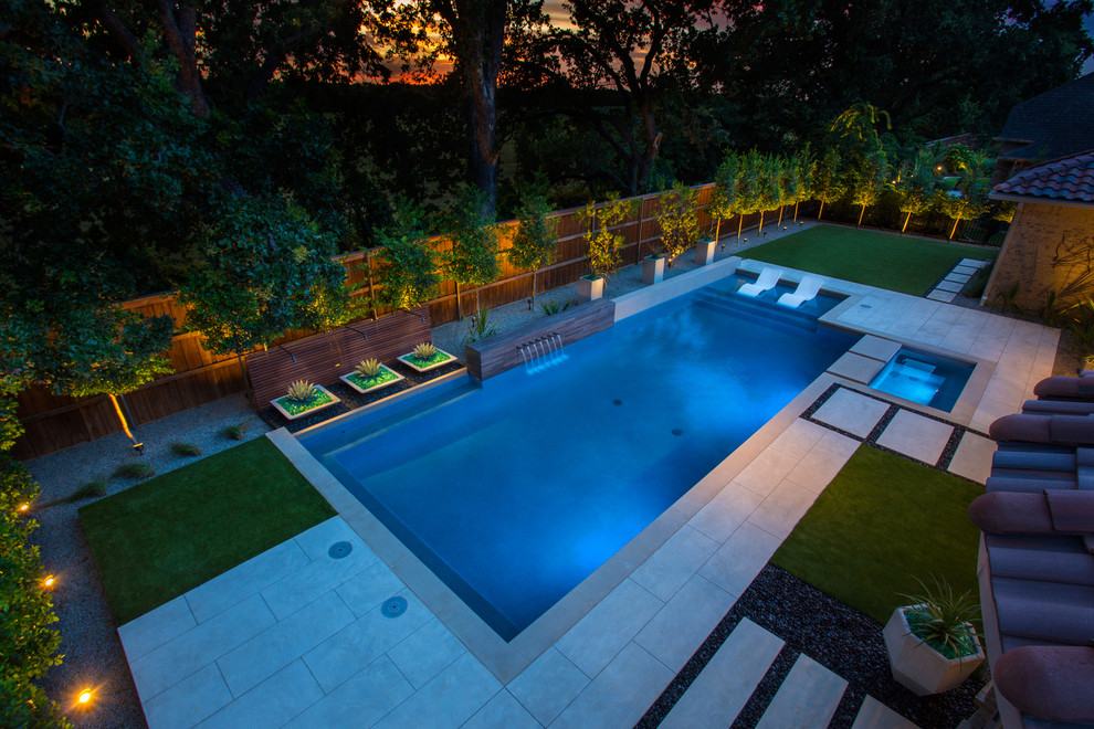 Foto de piscina con fuente alargada actual rectangular en patio trasero con adoquines de hormigón