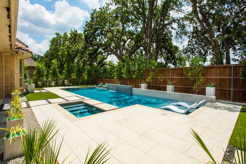 Foto de piscina con fuente alargada actual rectangular en patio trasero con losas de hormigón