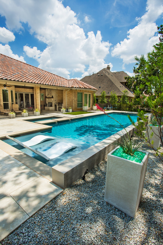 Diseño de piscina con fuente alargada contemporánea rectangular en patio trasero con losas de hormigón