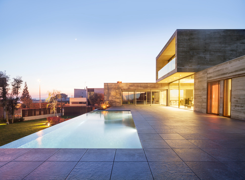 Imagen de casa de la piscina y piscina infinita contemporánea de tamaño medio rectangular en patio trasero con suelo de baldosas
