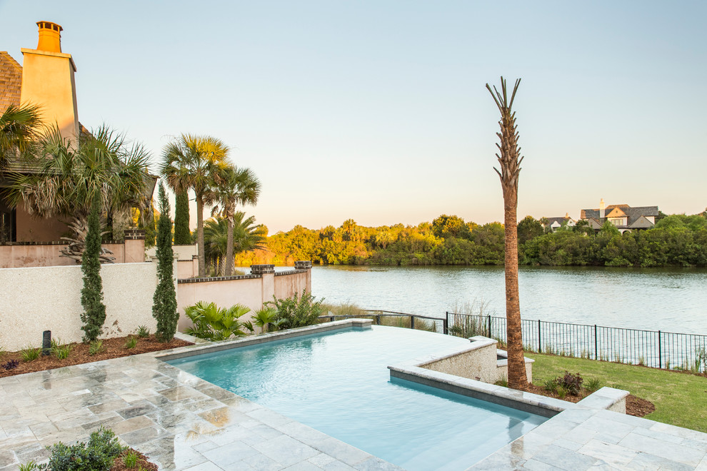 Inspiration for a small classic back l-shaped infinity swimming pool in Charleston with natural stone paving.
