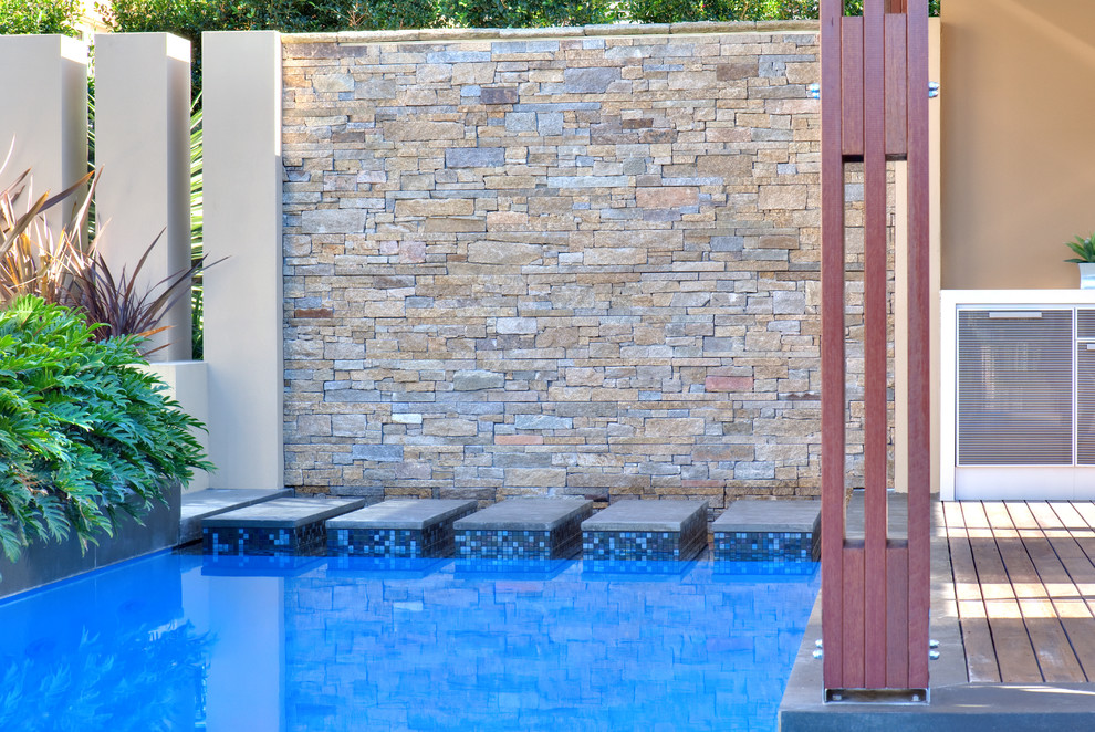 Foto di una piscina minimalista personalizzata di medie dimensioni e dietro casa con una dépendance a bordo piscina e pedane