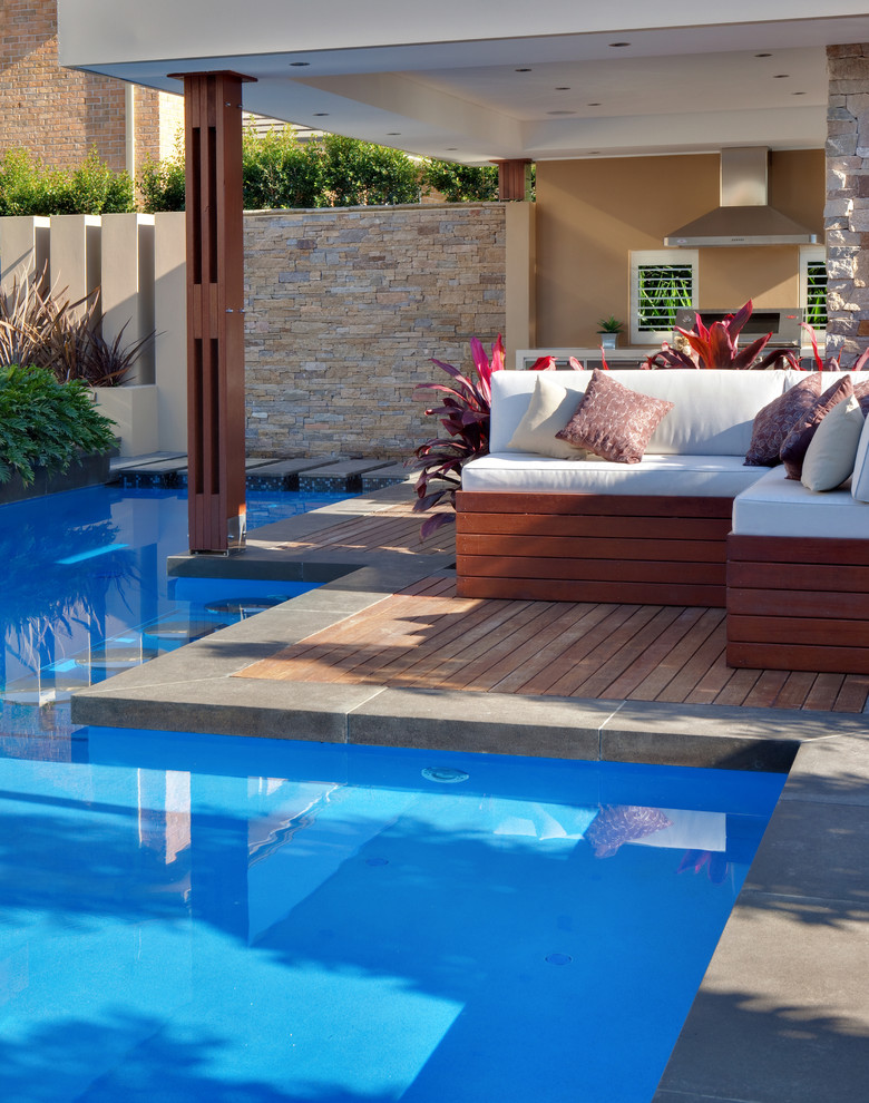Идея дизайна: бассейн среднего размера, произвольной формы на заднем дворе в стиле модернизм с домиком у бассейна и настилом