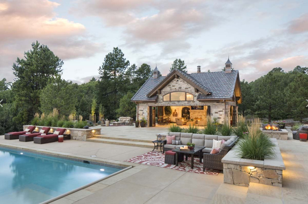 Ejemplo de casa de la piscina y piscina infinita clásica extra grande rectangular en patio trasero con suelo de baldosas