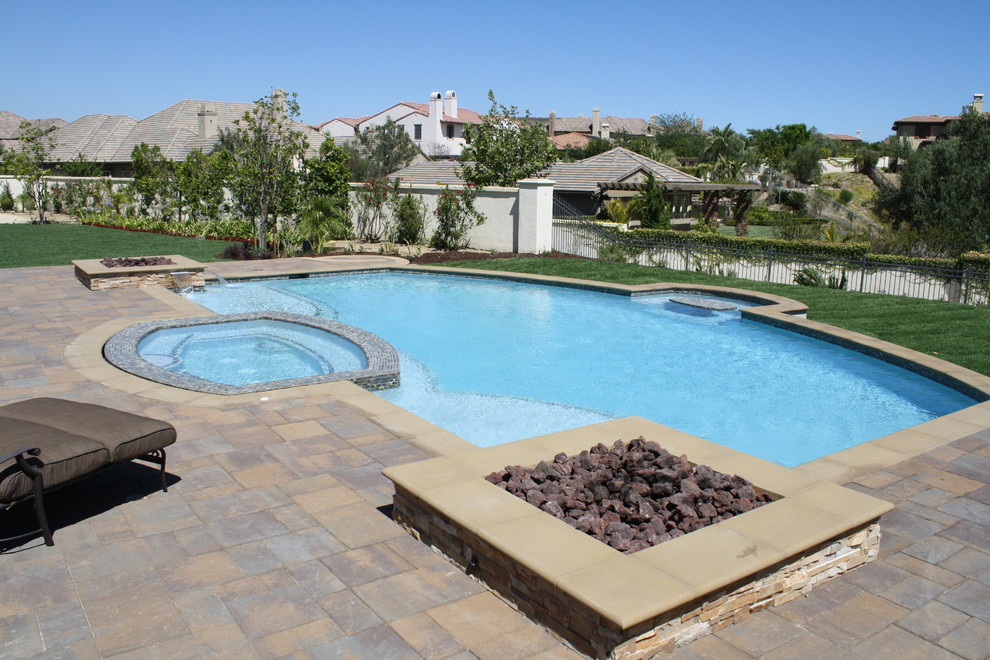 Modelo de piscinas y jacuzzis alargados mediterráneos de tamaño medio a medida en patio trasero con adoquines de piedra natural