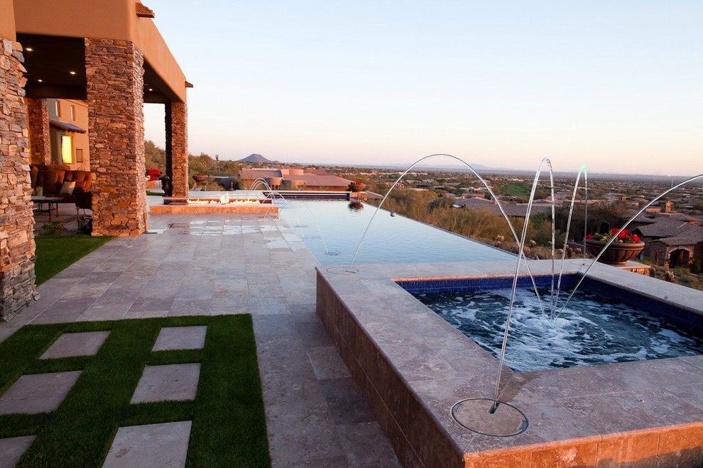 Inspiration for a large contemporary backyard stone and l-shaped infinity pool fountain remodel in Phoenix