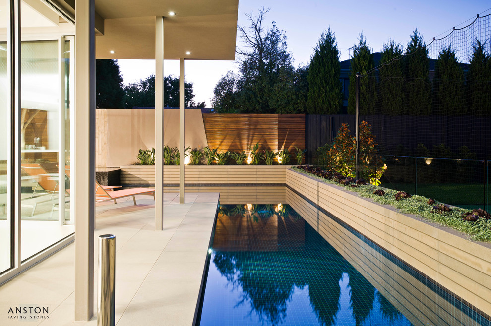 На фото: бассейн произвольной формы на заднем дворе в современном стиле с мощением тротуарной плиткой