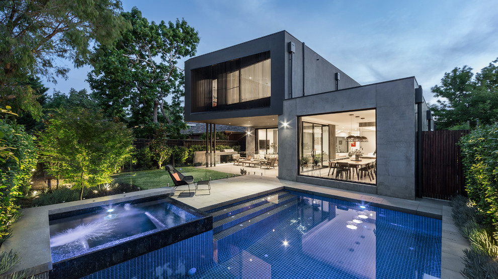 Diseño de piscinas y jacuzzis alargados contemporáneos rectangulares en patio trasero con adoquines de hormigón