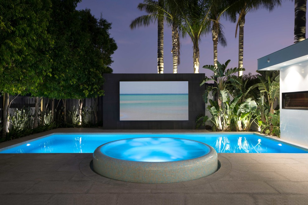 Example of a large minimalist backyard stone and rectangular lap hot tub design in Melbourne