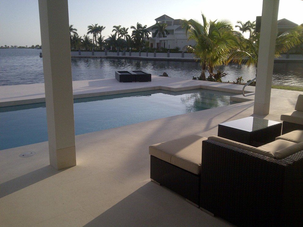 Идея дизайна: огромный естественный, прямоугольный бассейн на заднем дворе в морском стиле с джакузи и покрытием из бетонных плит