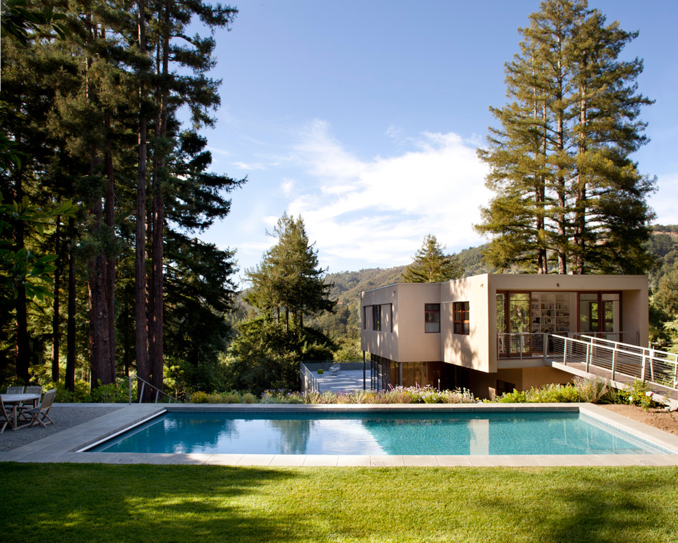 Idee per una grande piscina moderna rettangolare davanti casa con pavimentazioni in cemento