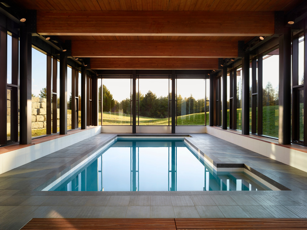 Large contemporary indoor rectangular swimming pool in Toronto with a pool house.