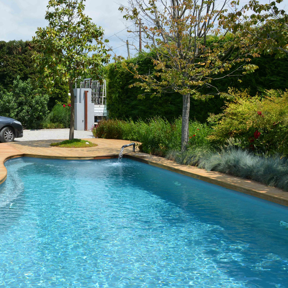 Esempio di una piscina naturale minimal personalizzata di medie dimensioni e nel cortile laterale con pedane