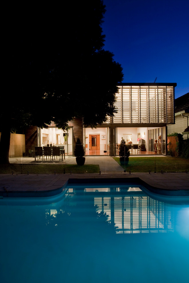 Стильный дизайн: большой бассейн произвольной формы на заднем дворе в современном стиле - последний тренд