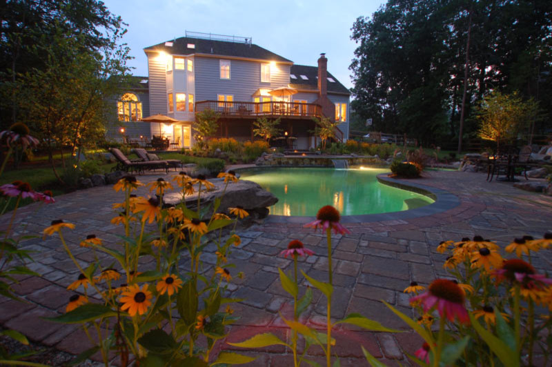 Immagine di una piscina naturale eclettica personalizzata di medie dimensioni e dietro casa con fontane e pavimentazioni in cemento