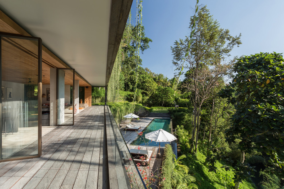 Foto di una piscina a sfioro infinito tropicale rettangolare dietro casa