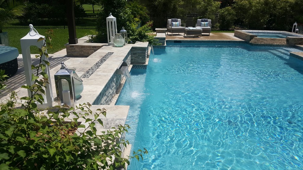 Exemple d'une grande piscine arrière chic rectangle avec des pavés en pierre naturelle.