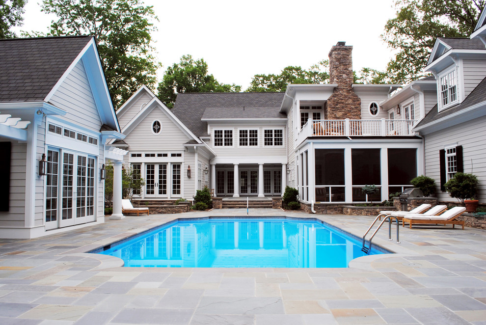 Modelo de piscina tradicional de tamaño medio a medida en patio trasero con suelo de baldosas