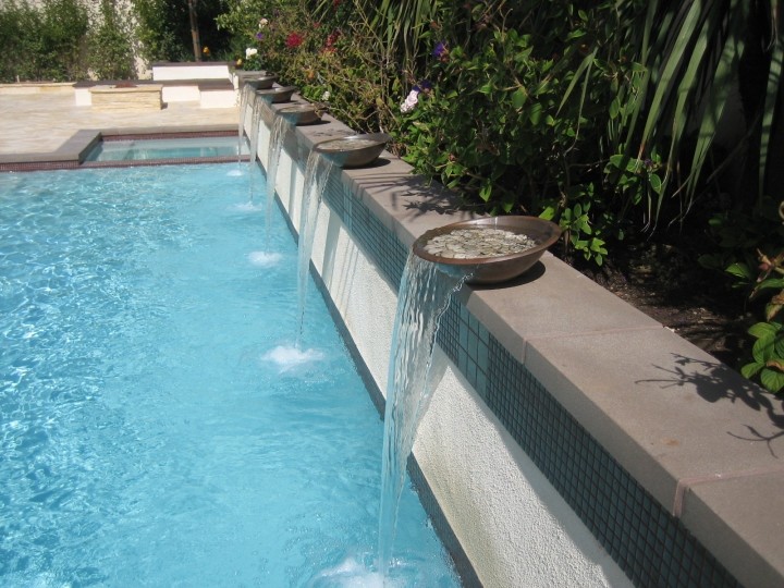 Inspiration för en liten funkis rektangulär pool på baksidan av huset, med en fontän och naturstensplattor