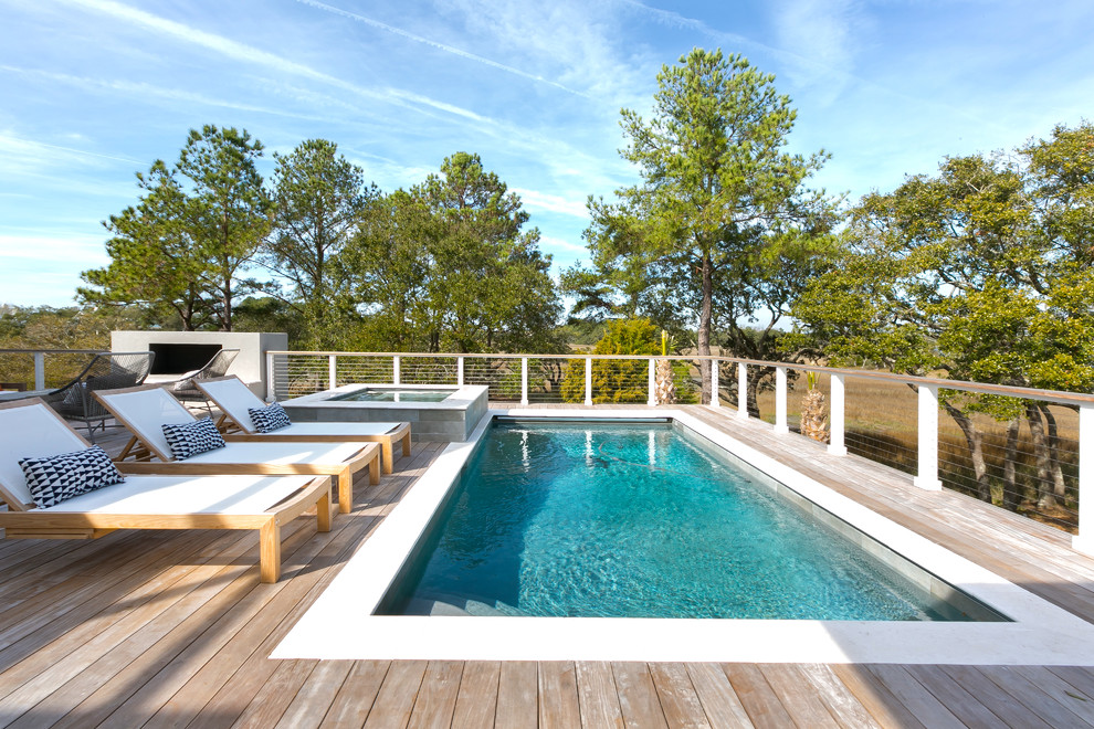 Cette image montre une piscine arrière design rectangle avec une terrasse en bois.